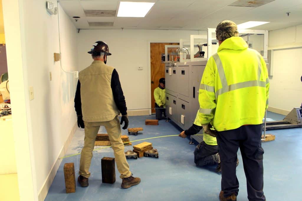 A half dozen employees help move the Humidichip assembly machine down the hall.