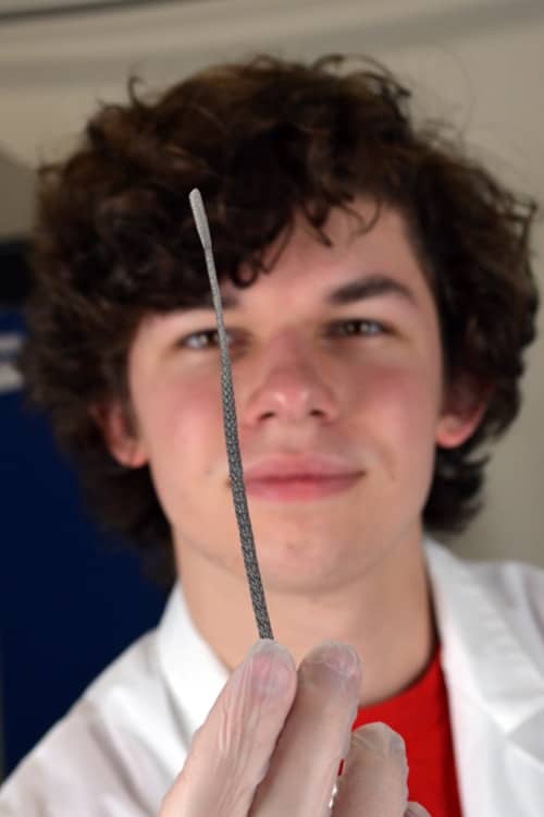 Carl May holds up one of hundreds of thousands of 3D printed COVID testing swabs he helped sterilize